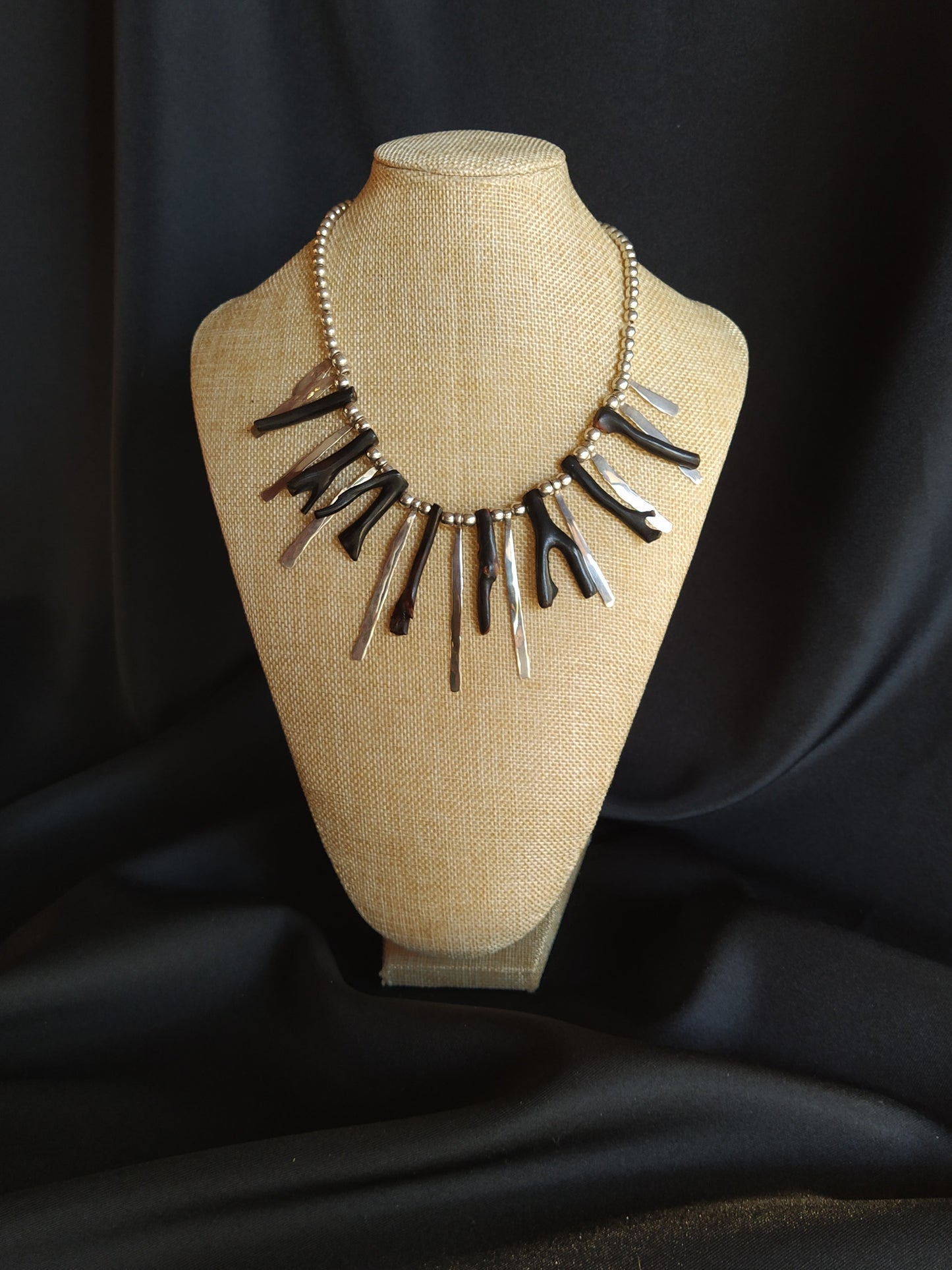 Collar con brazos de coral negro y lengüetas de plata martelinada.